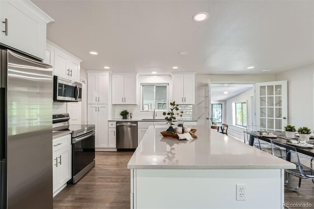 1926 S Yates St, Denver, CO 80219 - kitchen with appliances with stainless steel finishes, backsplash, a center island, white cabinetry, and recessed lighting
