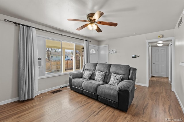 living room with a ceiling fan, baseboards, visible vents, and wood finished floors