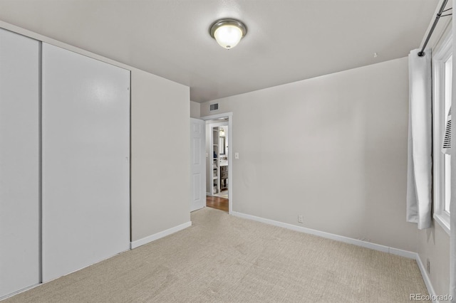 unfurnished bedroom featuring a closet, carpet flooring, visible vents, and baseboards