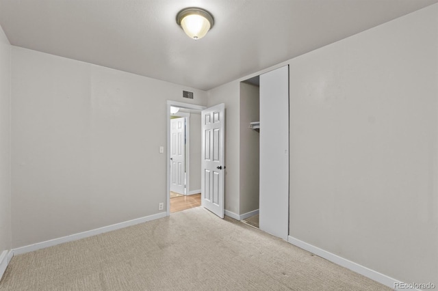 unfurnished bedroom featuring a closet, carpet, visible vents, and baseboards