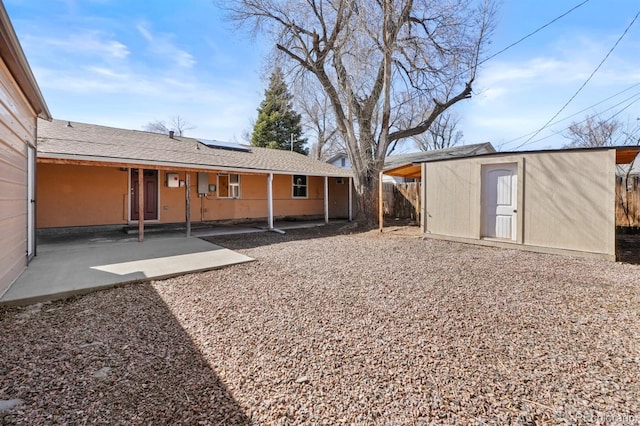 view of yard with a patio area, an outdoor structure, a storage unit, and fence