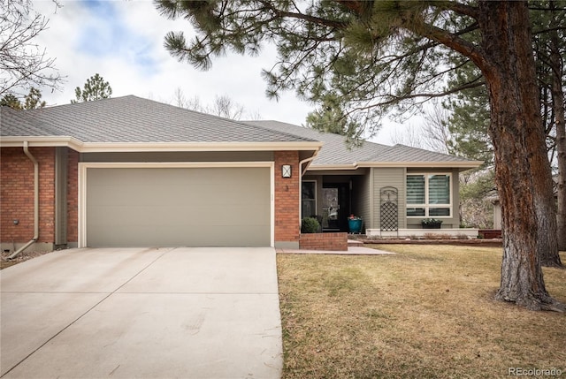 ranch-style home featuring driveway, roof with shingles, an attached garage, a front yard, and brick siding