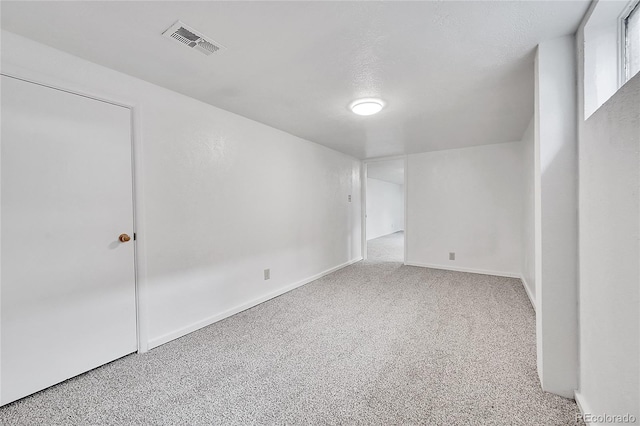 carpeted empty room featuring a textured ceiling