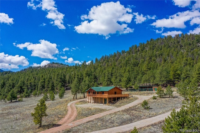 view of mountain backdrop featuring a heavily wooded area