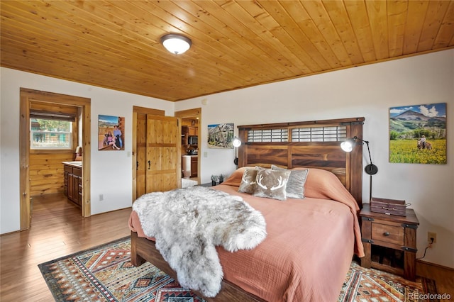 bedroom featuring wood ceiling, wood finished floors, and ensuite bath