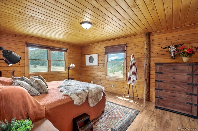 bedroom featuring wood ceiling, multiple windows, wood walls, and wood finished floors