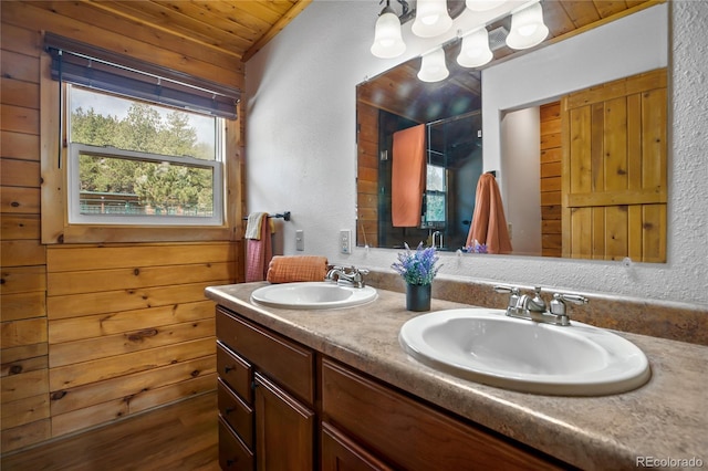 bathroom with wooden ceiling, a textured wall, a stall shower, and double vanity
