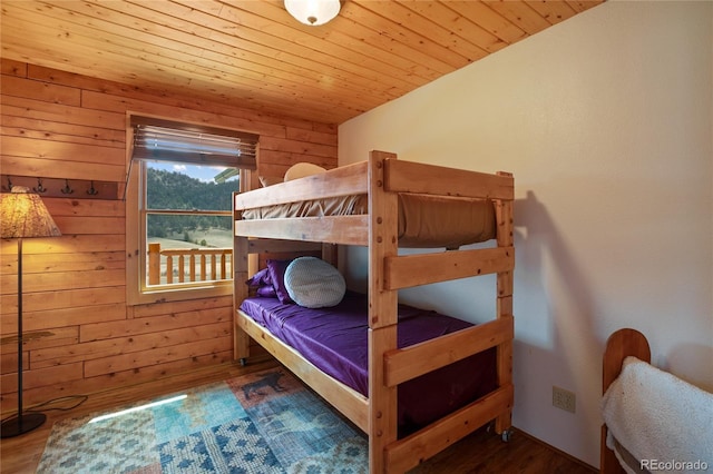 bedroom featuring wood walls, wooden ceiling, and wood finished floors