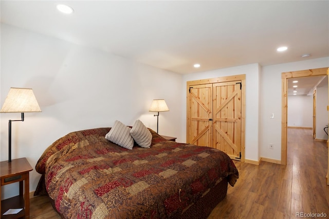 bedroom with wood finished floors, recessed lighting, and baseboards