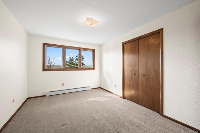 1198 Crestmoor Dr, Boulder, CO 80303 - unfurnished bedroom featuring a baseboard heating unit, light carpet, and a closet