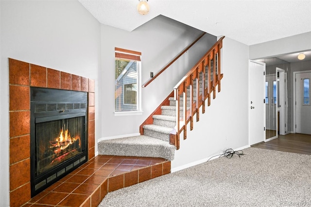 staircase featuring carpet flooring and a fireplace