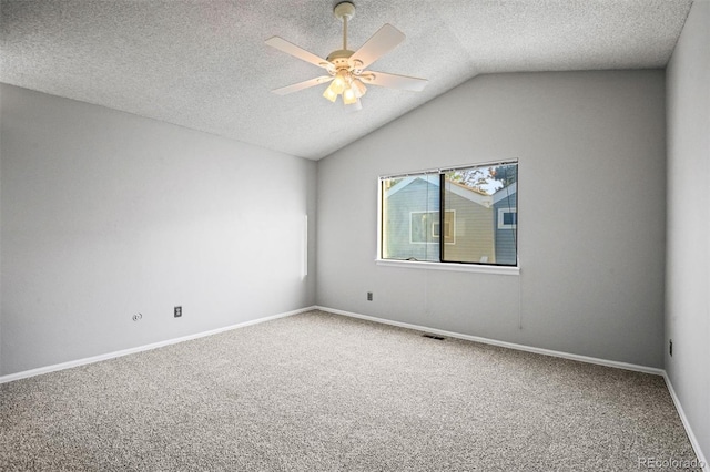 carpeted spare room featuring a textured ceiling, ceiling fan, and vaulted ceiling