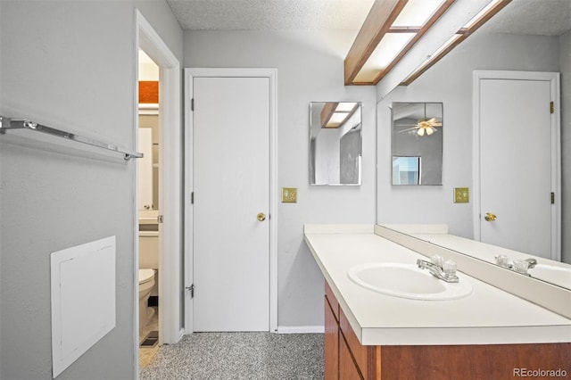 bathroom featuring vanity, toilet, and a textured ceiling