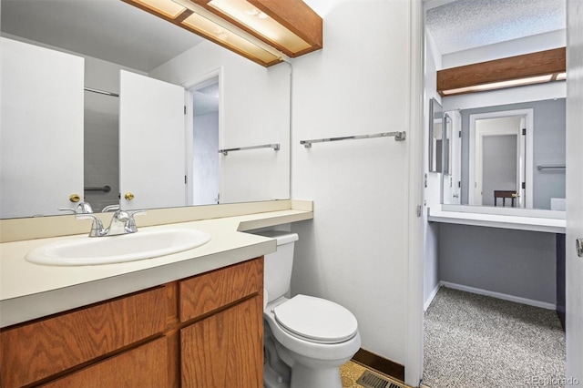 bathroom with vanity, a textured ceiling, and toilet