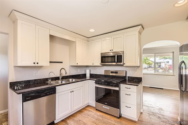 4111 S Delaware St, Englewood, CO 80110 - kitchen featuring stainless steel appliances, light wood-type flooring, white cabinets, dark stone counters, and recessed lighting