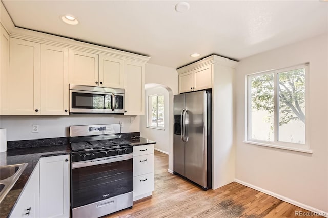 4111 S Delaware St, Englewood, CO 80110 - kitchen with appliances with stainless steel finishes, arched walkways, plenty of natural light, light wood finished floors, and recessed lighting
