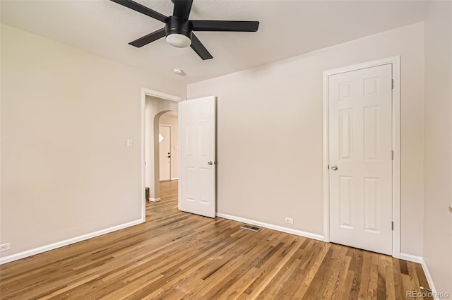 4111 S Delaware St, Englewood, CO 80110 - unfurnished bedroom featuring light wood-style floors, arched walkways, and a ceiling fan