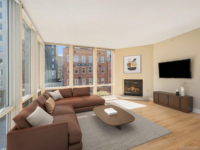 living room with light wood-type flooring and floor to ceiling windows