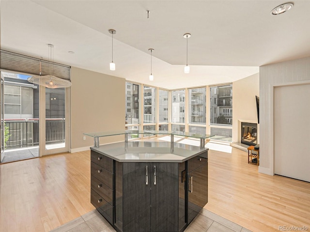 kitchen with a healthy amount of sunlight, a center island, pendant lighting, and dark brown cabinets