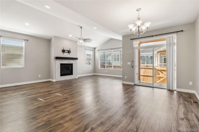 unfurnished living room featuring vaulted ceiling, dark hardwood / wood-style flooring, and ceiling fan with notable chandelier