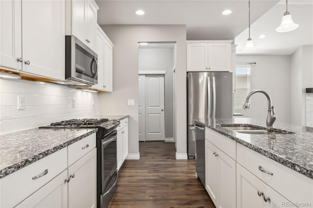 kitchen with white cabinetry, sink, dark stone counters, and appliances with stainless steel finishes