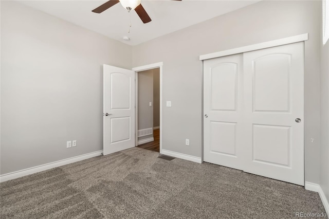 unfurnished bedroom with dark carpet, a closet, and ceiling fan