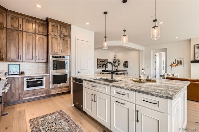 668 Leafy Aster Ln, Castle Rock, CO 80104 - kitchen with a sink, appliances with stainless steel finishes, light stone countertops, white cabinets, and recessed lighting
