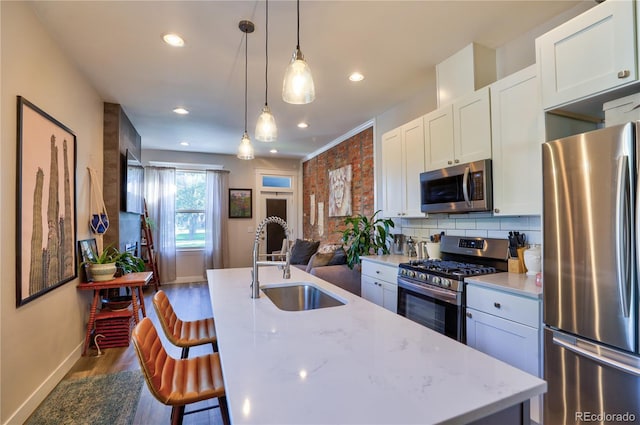 1739 E Martin Luther King Jr Blvd, Denver, CO 80205 - kitchen with stainless steel appliances, dark wood-style flooring, white cabinets, a breakfast bar, and decorative backsplash