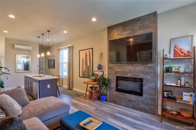 1739 E Martin Luther King Jr Blvd, Denver, CO 80205 - living area featuring a wall mounted air conditioner, wood finished floors, recessed lighting, and a fireplace