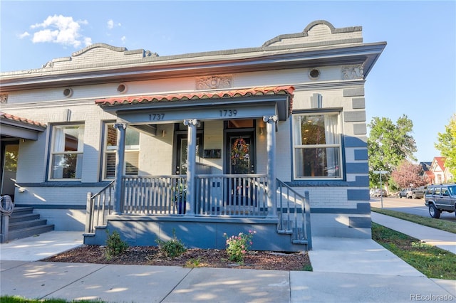1739 E Martin Luther King Jr Blvd, Denver, CO 80205 - view of front facade featuring covered porch and brick siding