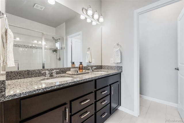 bathroom with an enclosed shower, vanity, and tile patterned floors