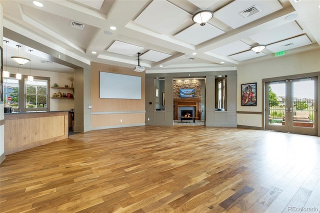 unfurnished living room featuring light hardwood / wood-style floors, beam ceiling, french doors, and coffered ceiling