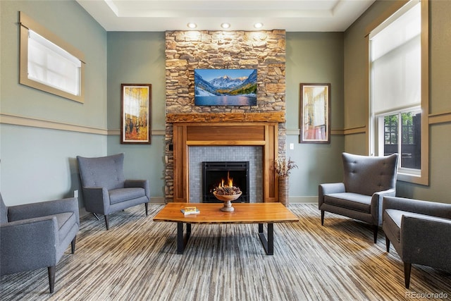 sitting room featuring a large fireplace and a tray ceiling