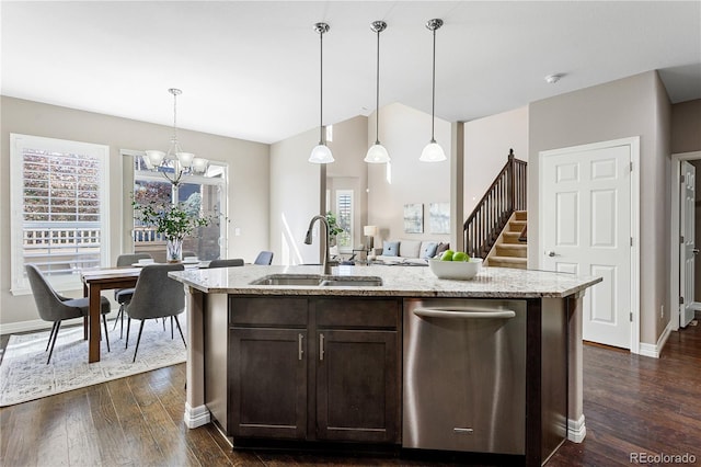 kitchen with hanging light fixtures, sink, a center island with sink, and dark brown cabinetry