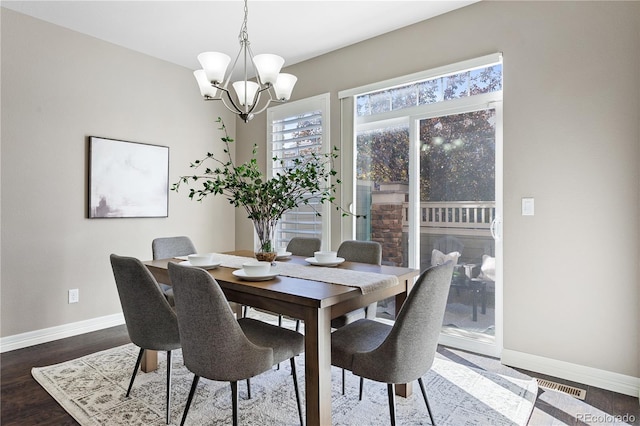 dining area featuring hardwood / wood-style floors and a notable chandelier