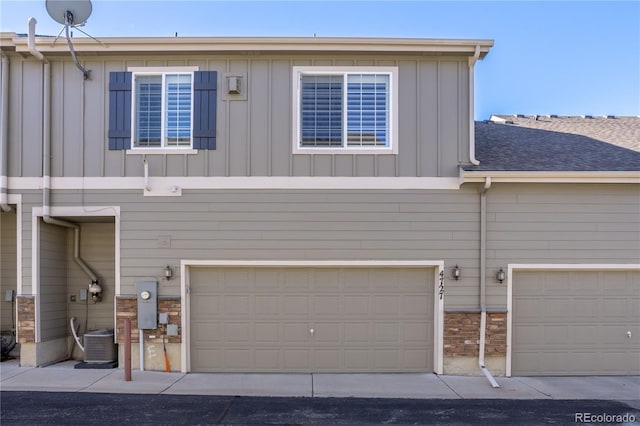 view of front facade featuring central AC and a garage