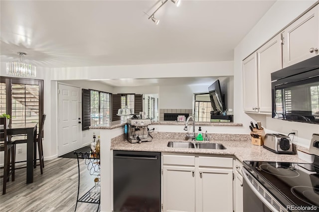 kitchen featuring black microwave, a peninsula, electric range, a sink, and dishwasher