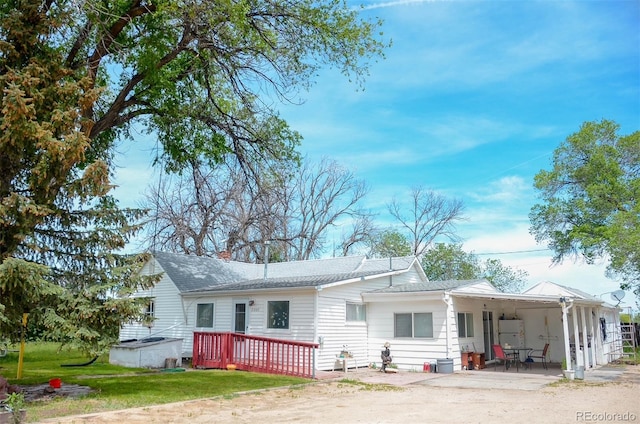 21064 Kelly St, Matheson, CO 80830 - rear view of house featuring driveway, a yard, roof with shingles, and a wooden deck