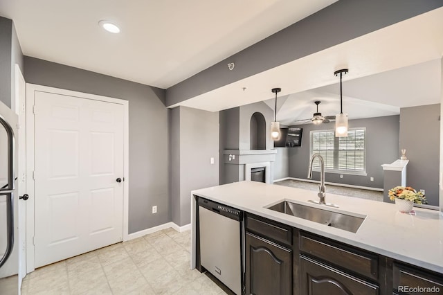 12824 Ironstone Way Unit 303, Parker, CO 80134 - kitchen with dishwasher, a glass covered fireplace, ceiling fan, light countertops, and pendant lighting