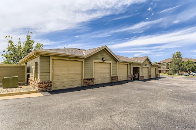 12824 Ironstone Way Unit 303, Parker, CO 80134 - view of front of home with community garages, brick siding, and an outbuilding