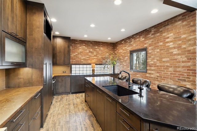 114 El Paso Blvd, Manitou Springs, CO 80829 - kitchen featuring light wood-style flooring, recessed lighting, brick wall, modern cabinets, and dark brown cabinets