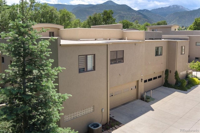 114 El Paso Blvd, Manitou Springs, CO 80829 - view of building exterior featuring a garage, driveway, and a mountain view