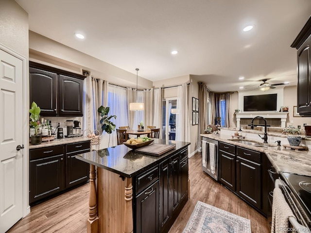 9412 Burgundy Cir, Highlands Ranch, CO 80126 - kitchen with electric range, ceiling fan, dark stone countertops, light wood finished floors, and open floor plan