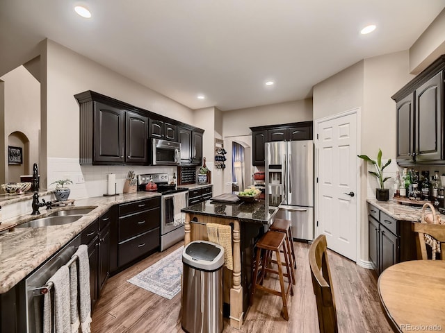 9412 Burgundy Cir, Highlands Ranch, CO 80126 - kitchen featuring appliances with stainless steel finishes, light stone countertops, light wood-style floors, and recessed lighting