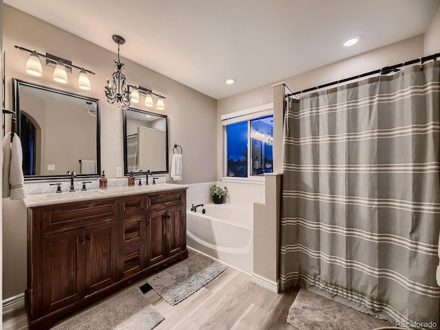 9412 Burgundy Cir, Highlands Ranch, CO 80126 - bathroom with wood finished floors, double vanity, a garden tub, a shower with curtain, and recessed lighting