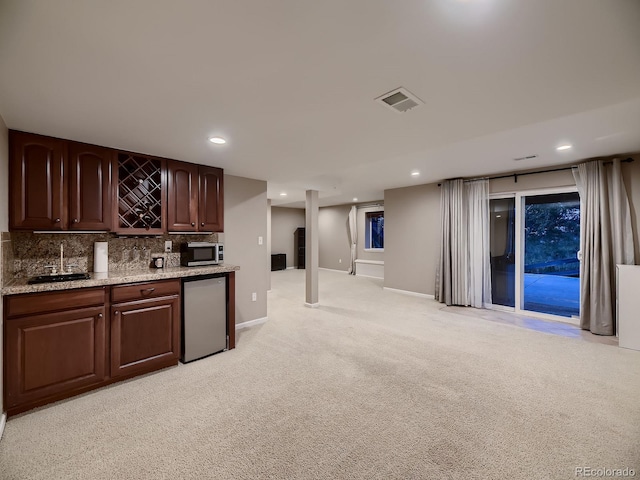 9412 Burgundy Cir, Highlands Ranch, CO 80126 - indoor wet bar featuring fridge, light carpet, decorative backsplash, recessed lighting, and stainless steel microwave
