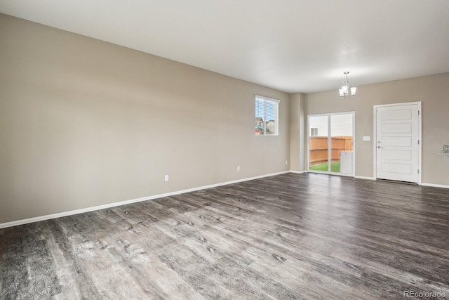 empty room featuring an inviting chandelier and hardwood / wood-style flooring