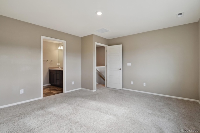 unfurnished bedroom featuring connected bathroom and carpet