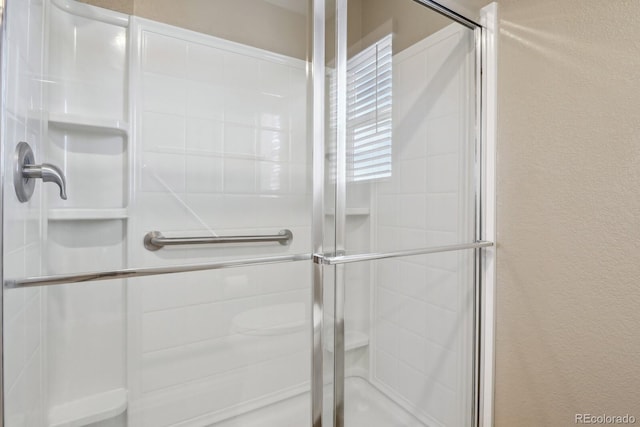 bathroom with a shower with door