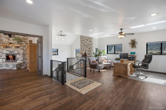 living room featuring ceiling fan, dark wood-type flooring, a fireplace, and vaulted ceiling